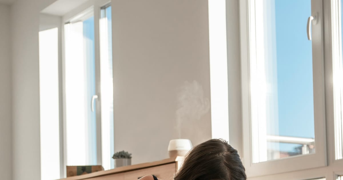 Una mujer sostiene una posición de plancha sobre un tapete de yoga.