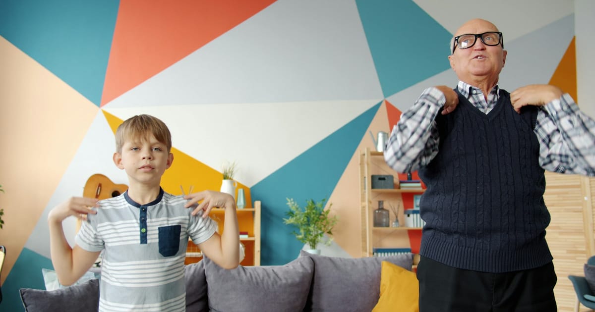 Un abuelo y su nieto haciendo ejercicios juntos en casa.
